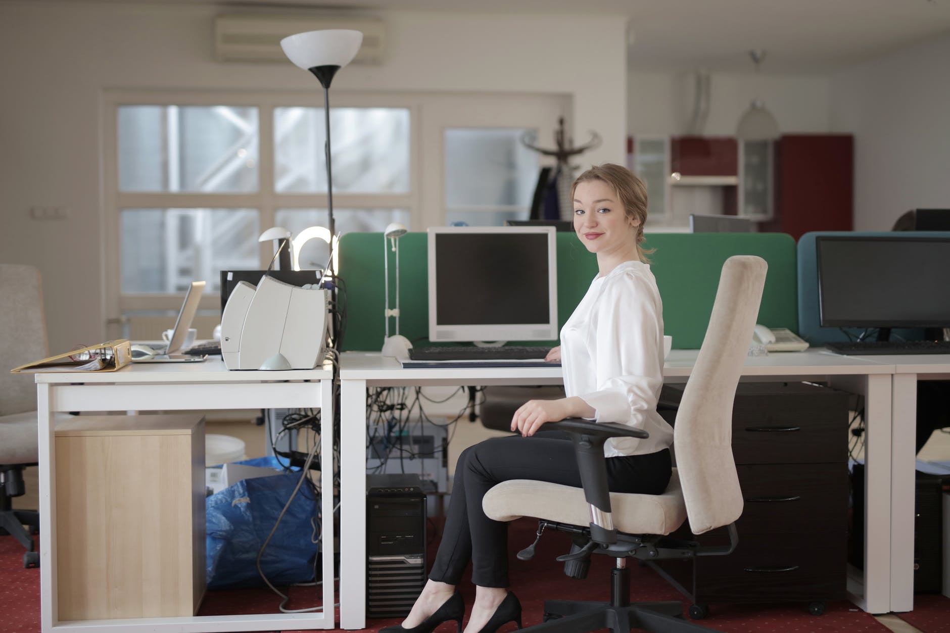 elegant female employee sitting on chair in modern workplace