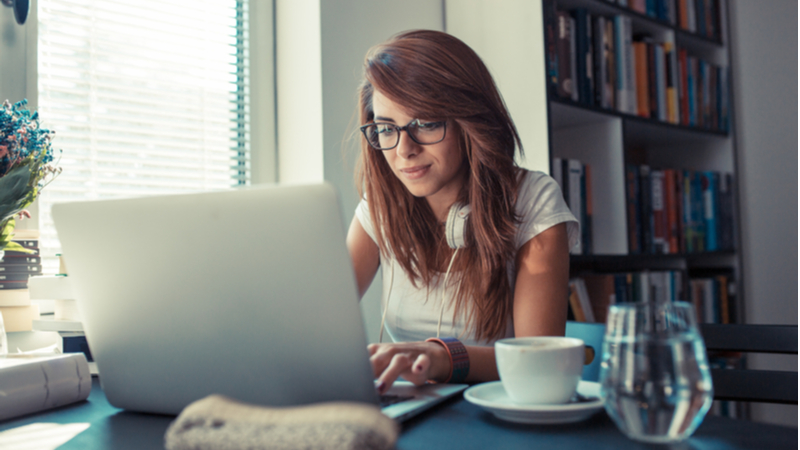 young woman typing on her laptop in her home office