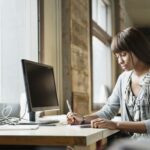 african american woman taking notes in her home office