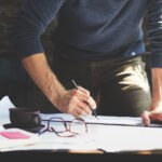 Man planning dissertation timeline at desk