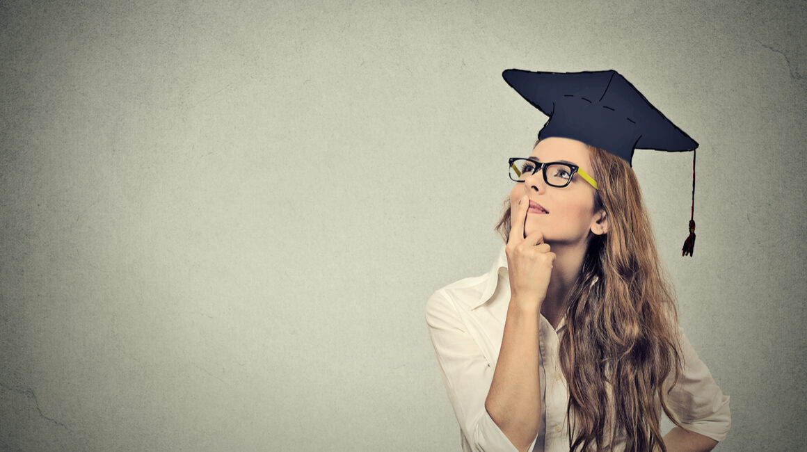 Woman wearing graduation cap wondering if her phd was worth it