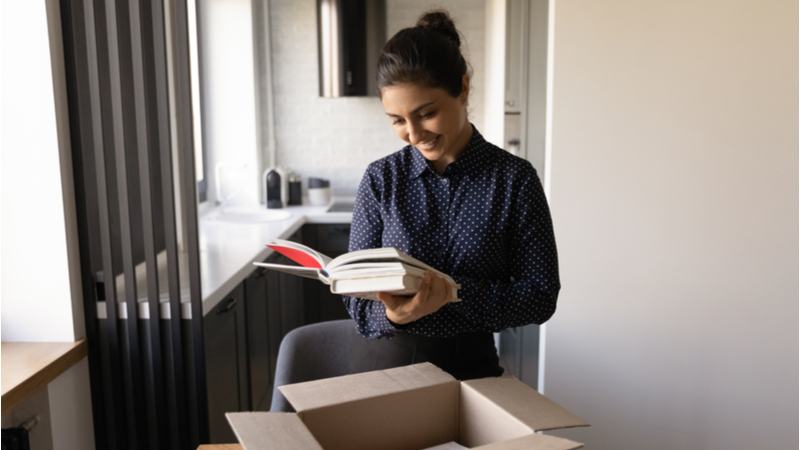 woman opening a box containing books