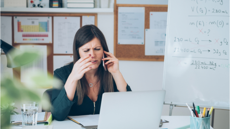 Upset woman talking on the phone in her office