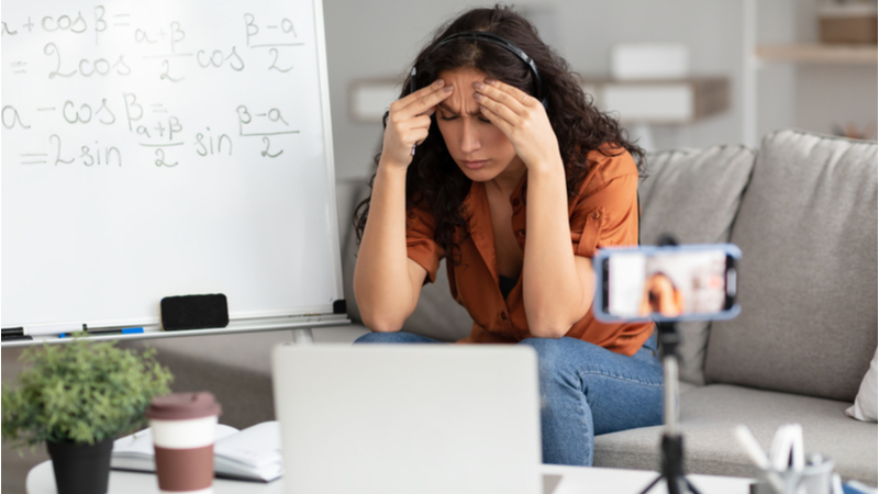 stressed out woman trying to figure out math problems in front of her laptop