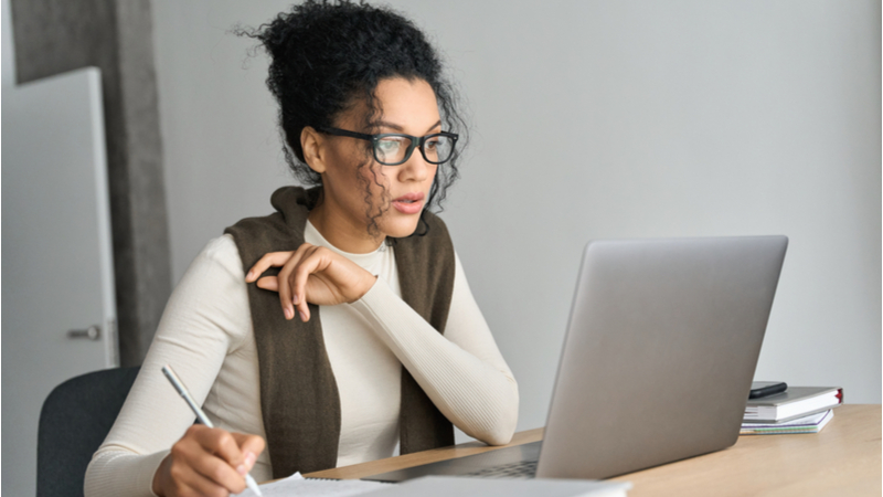 woman puzzling over how to write a dissertation abstract, sitting in front of computer