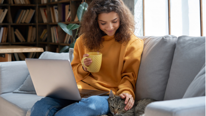 woman in yellow sweater relaxingly studying at home
